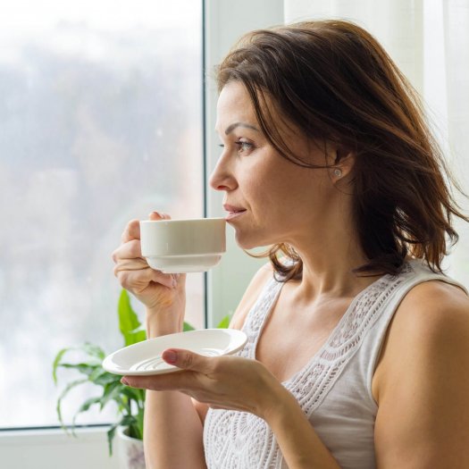 Mature woman drinks morning coffee